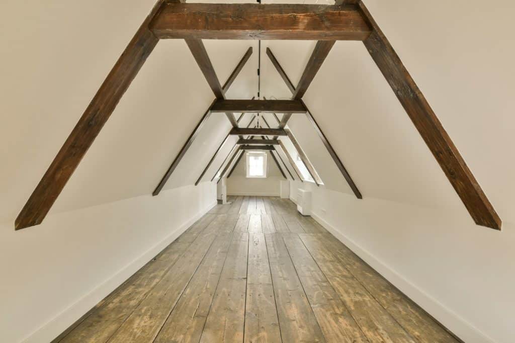 a attic conversion with wooden beams and white walls